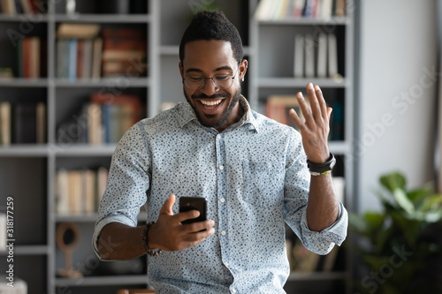 Cuadro en lienzo Excited happy african businessman celebrate read good news on smartphone