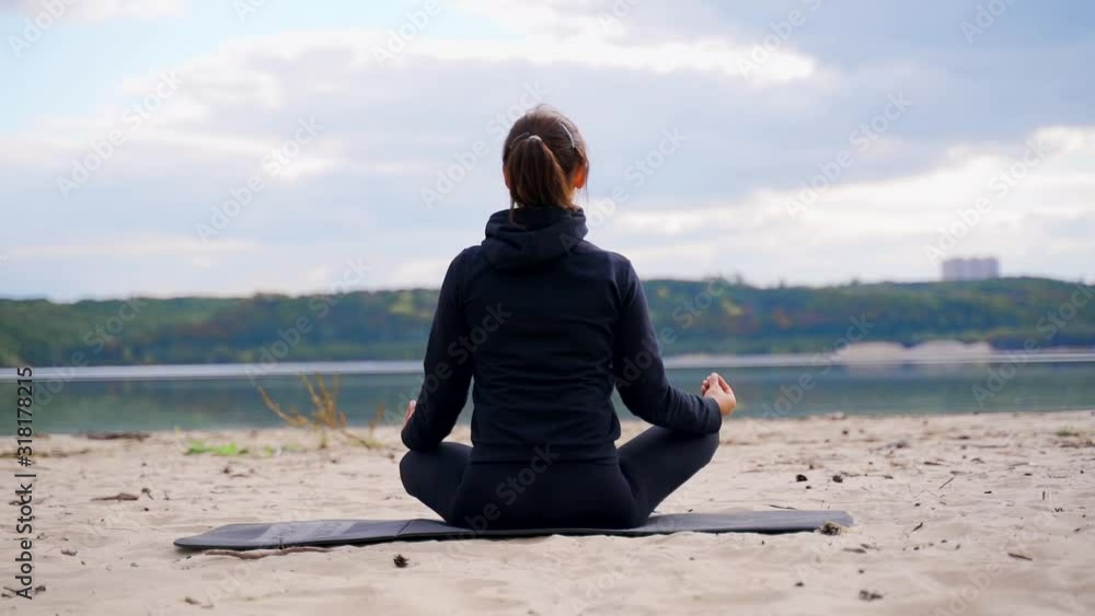 woman is meditating while sitting on beach when doing yoga. woman is meditating while sitting on beach when doing yoga.