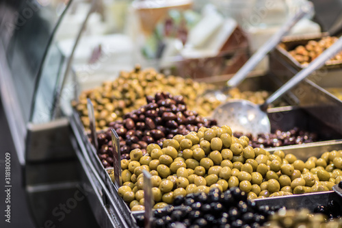 Pickled, brown, black, green, and red olives. Authentic Middle Eastern and Syrian style. Against a blurry background. For Sale in Old Market, Jerusalem.