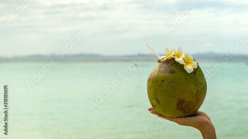 Travel concept. Coconut with flowers on sand beach, Banul beach, Coron, Palawan, Philippines