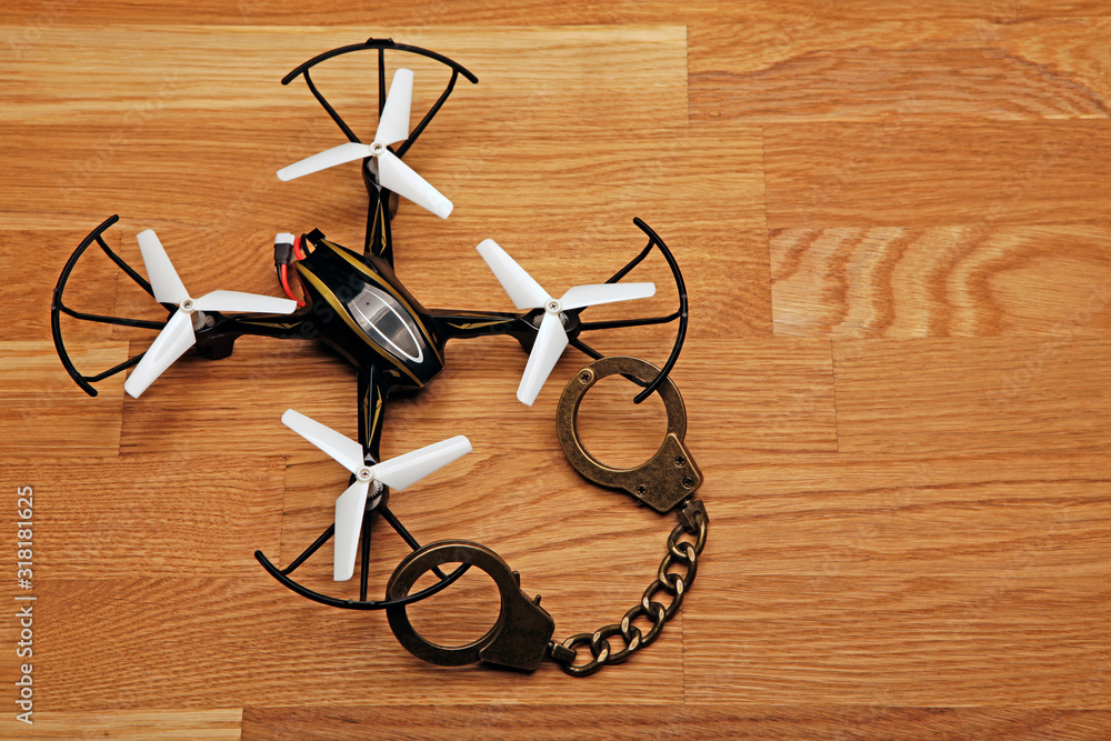 quadcopter handcuffs wooden desk background 