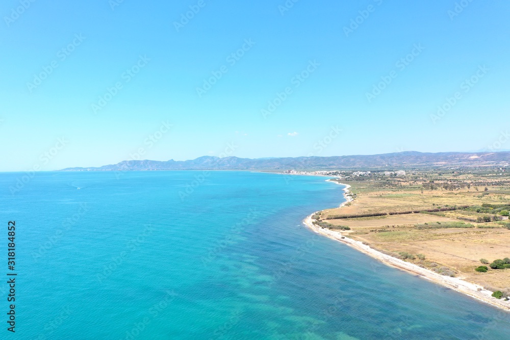 Costa Del Azahar, Valencian Community, Spain. Beautiful unique drone shot of the spanish mediterranean sea coast. Cristal clear water, sunny summer day. Colorful landscape, turquoise water. 
