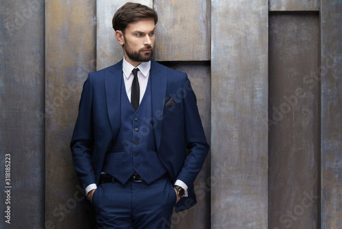 indoor photo of young handsome stylish businessman wearing suit photo