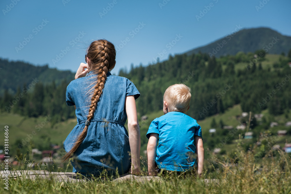 Young mother and little son in nature background nature. Countryside. Back view