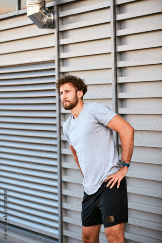 Young man exercising / stretching in urban area.