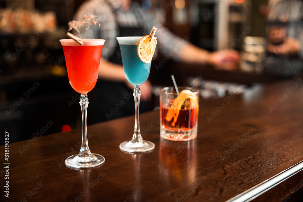 Naklejka premium Different multi-colored drinks on counter in bar