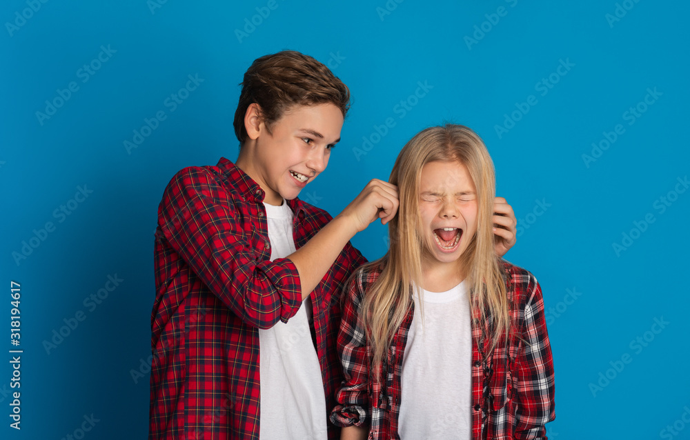 Elder brother teasing little sister, pulling her ears till she scream Elder brother teasing little sister, pulling her ears till she scream