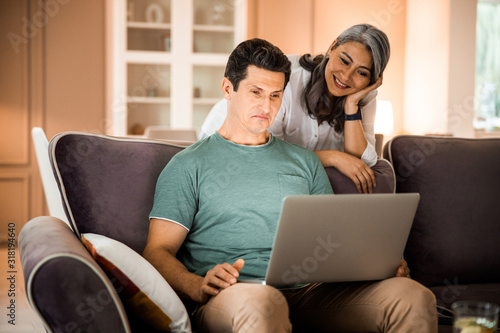 Smiling adult couple spending time in living room