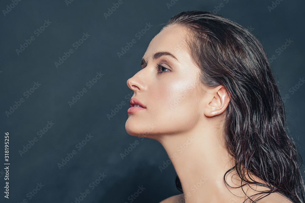 Beautiful female profile closeup. Attractive woman with wet skin on dark background Beautiful female profile closeup. Attractive woman with wet skin on dark background