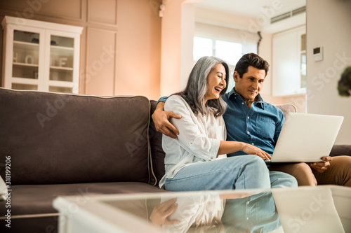 Happy pretty woman sitting next to her husband in room