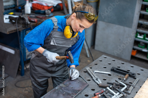 Sideview of worker woman marking piece of metal