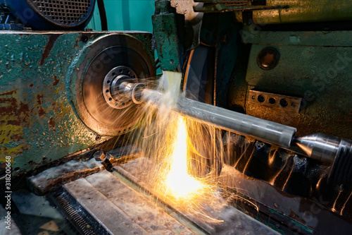 Grinding and high-precision shaft processing on a circular grinding machine with sparks and cooling.