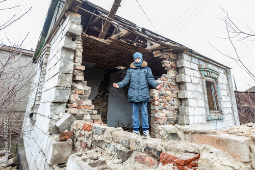 A boy in a ruined house, a teenager was left homeless as a result of military conflicts and natural disasters. © andov