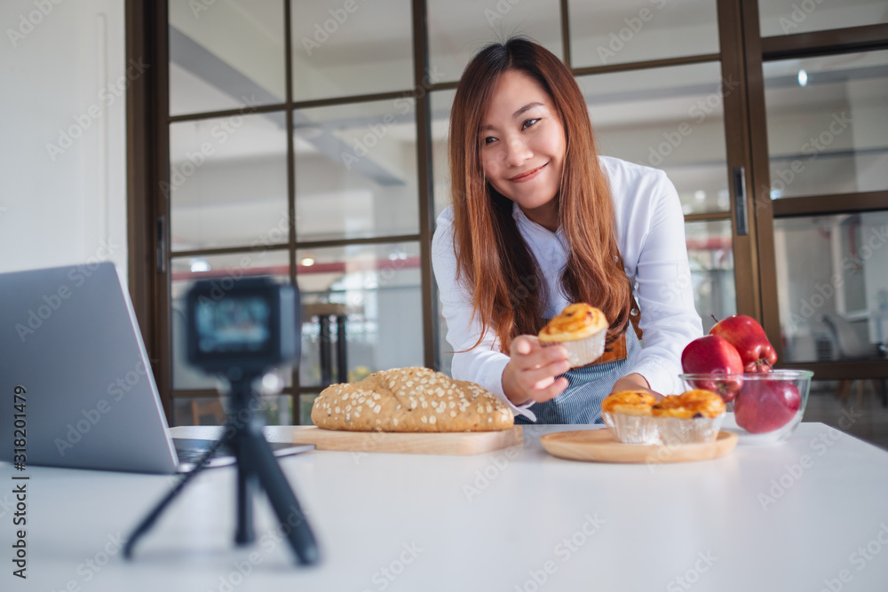 A beautiful asian woman food blogger or vlogger recording a video on camera A beautiful asian woman food blogger or vlogger recording a video on camera
