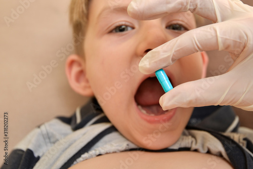 The doctor gives pills to a sick child to treat the disease and recover.