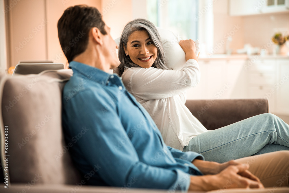 Happy adult woman holding a pillow in hands Happy adult woman holding a pillow in hands