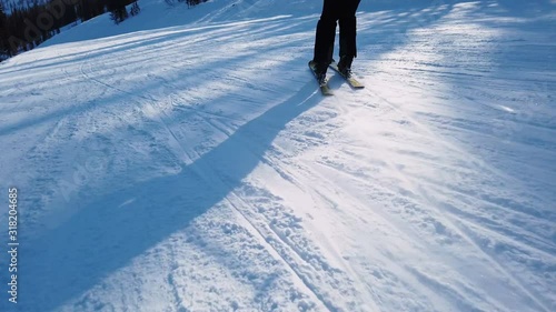 Young adult recreational skier enjoys idyllic perfect weather in cold winter. Skiing alone on perfectly groomed ski piste at ski resort