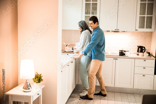Happy woman washing a cup in the kitchen
