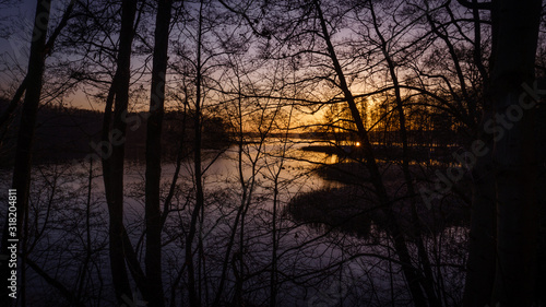 sunset on a lake through branches © Thorsten