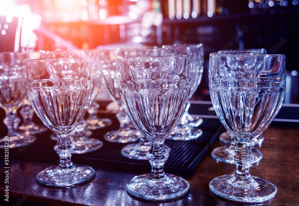 Wine and martini glasses in shelf above a bar rack in restaurant. Wine and martini glasses in shelf above a bar rack in restaurant.