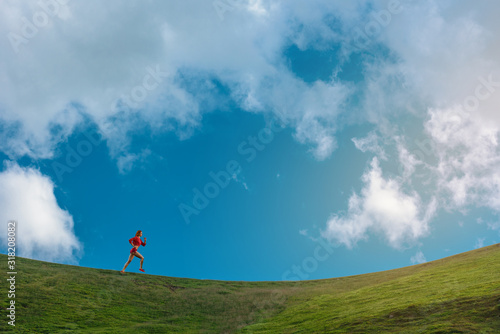 Beautiful slim athletic woman running on the cliff of mountain