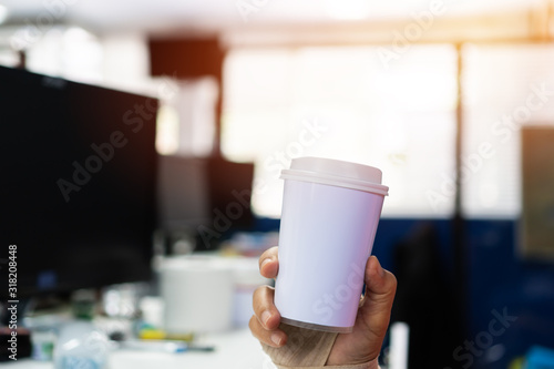 Businessman holding white Paper coffee cup mock-up for logo with document paperwork on meeting. Concept of business people working in office and save world. Mockup for word