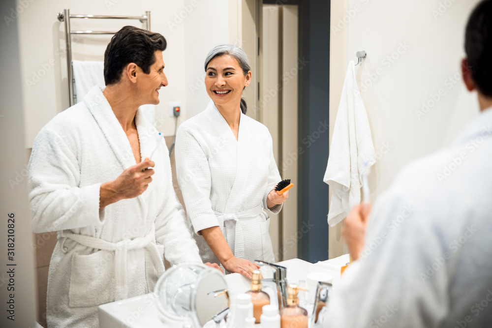 Happy mature man and woman standing in bathroom Happy mature man and woman standing in bathroom