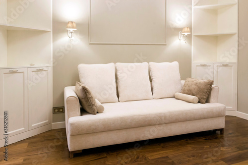 White sofa in a new, bright living room after repair. Laconic interior design