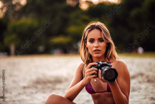 Foto Portrait of attractive female photographer on a beach, close-up.
