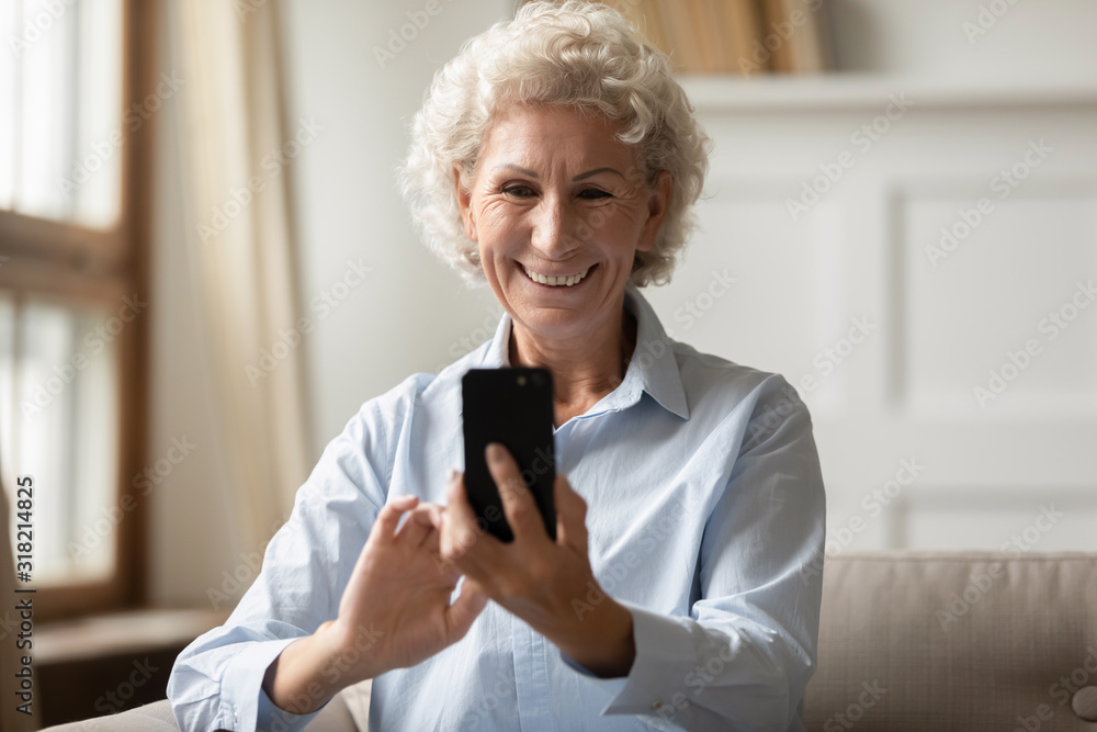 Happy 70s grandmother taking selfie on smartphone. Happy 70s grandmother taking selfie on smartphone.