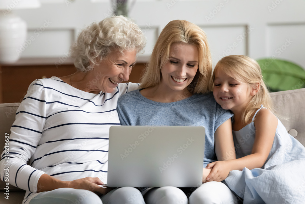 Happy three generations family looking at laptop screen. Happy three generations family looking at laptop screen.