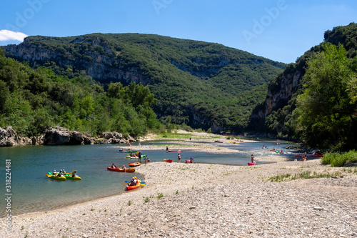 People canoeing and  kayaking in Ardeche river near Pont D'Arc in France photo
