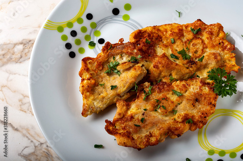 Chicken schnitzel on plate with herbs photo