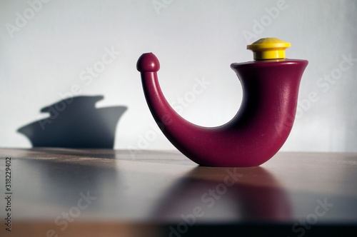 A neti pot for nasal irrigation in ancient Ayurvedic tradition. Personal hygiene practice in which the nasal cavity / sinuses are washed to flush out mucus and debris from the nose and sinuses. photo