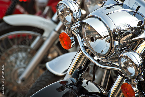 Motorcycles are placed in a row. Headlight closeup. Motorcycle chrome elements. © Ivan