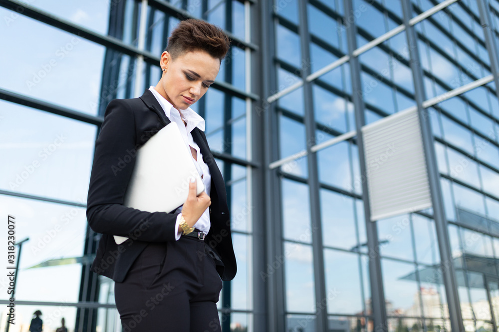 classic style office worker stands with papers at the facade of a modern glazed business center building classic style office worker stands with papers at the facade of a modern glazed business center building