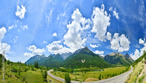 Panoramic view of summer mountains and a road