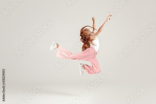 Inclusive Beauty. Girl with freckles jumping isolated on grey hands up joyful photo