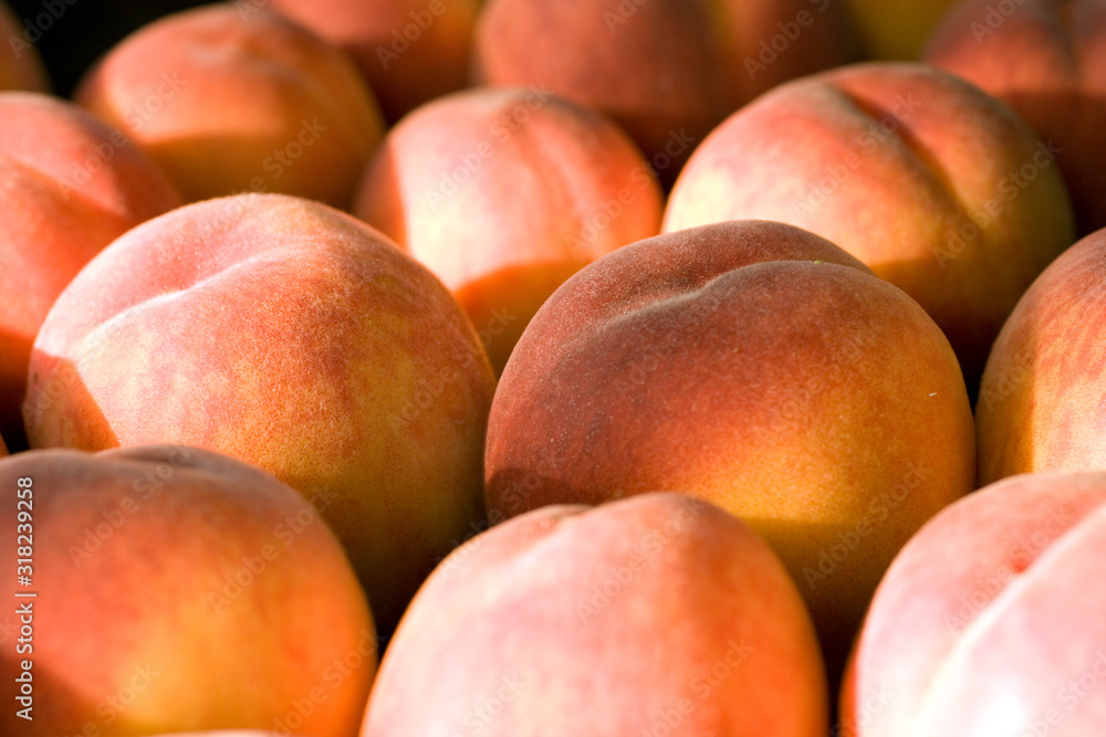 A group of ripe peaches in a bowl