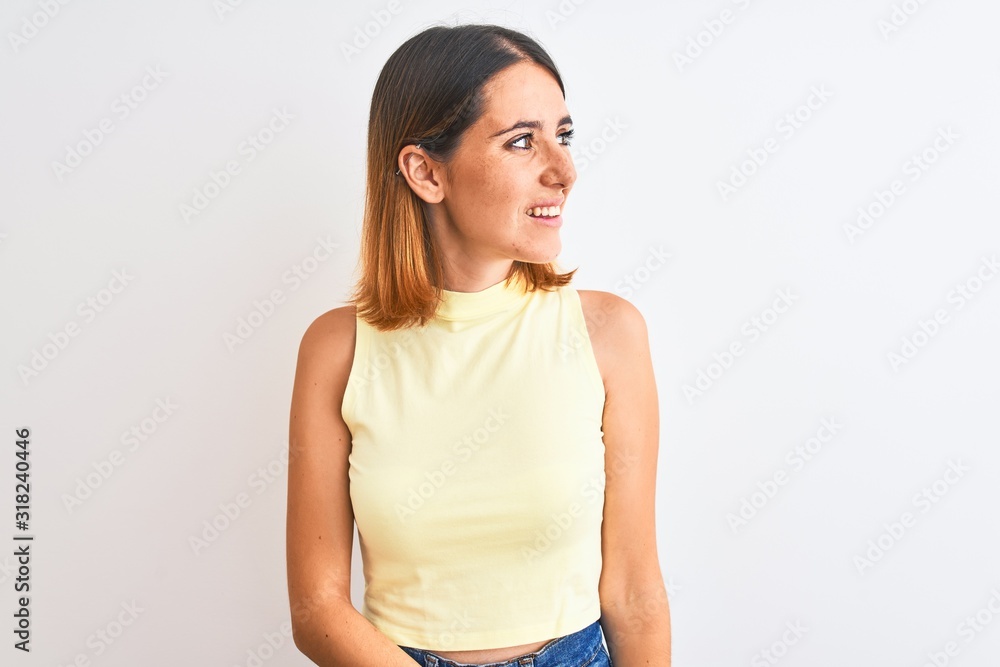 Beautiful redhead woman wearing yellow summer t-shirt over isolated background looking away to side with smile on face, natural expression. Laughing confident. Beautiful redhead woman wearing yellow summer t-shirt over isolated background looking away to side with smile on face, natural expression. Laughing confident.