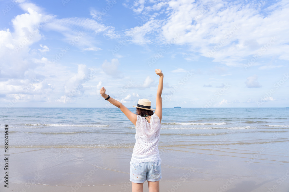 Outdoor summer portrait of Young Asian woman wearing stylish hat and clothes standing on the beach, enjoying looking view of sea with blue sky on summer vacation. Outdoor summer portrait of Young Asian woman wearing stylish hat and clothes standing on the beach, enjoying looking view of sea with blue sky on summer vacation.