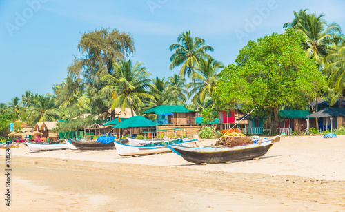 Beautiful beach view with fishing boat, yellow sand and blue ocean, Goa state in India © FakeMoon