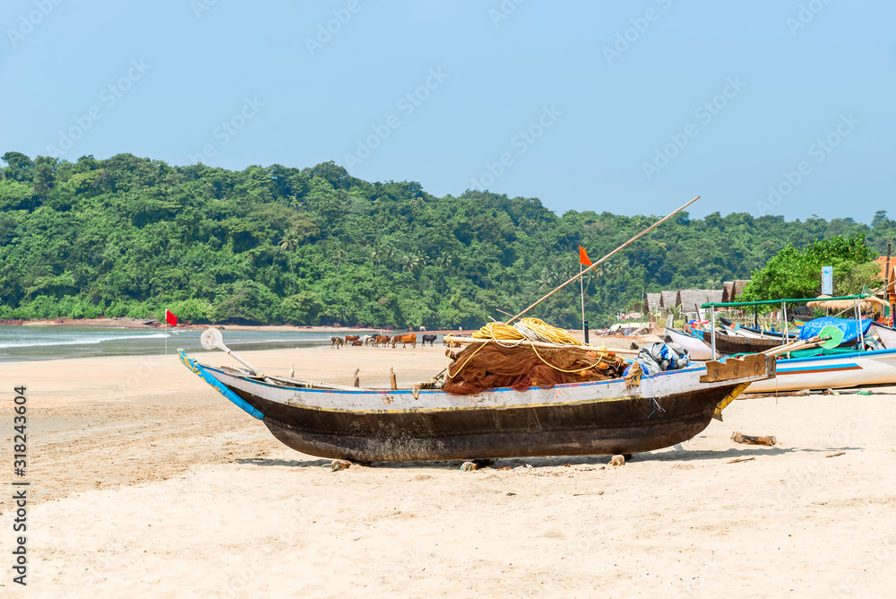 Beautiful beach view with fishing boat, yellow sand and blue ocean, Goa state in India