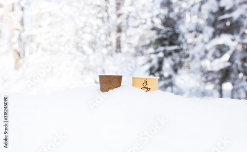 Obraz na plátně Two paper cups for a drink stand in a snowdrift in the winter
