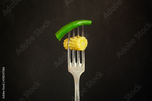 fresh vegetables on a fork, (baby corn, green beans and other healthy food) menu concept. background. top view. copy space