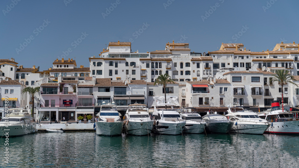 marbella marina cityscape on a sunny day with houses, boats and the sea, spain