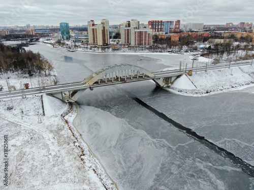 Aerial view beautiful urban landscape railway bridge over freezing river from drone