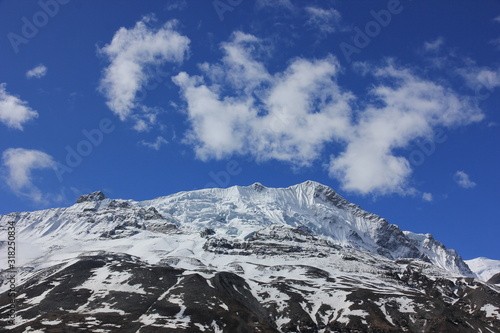 Snowy mountains against the blue sky with white clouds. Mountains of Nepal