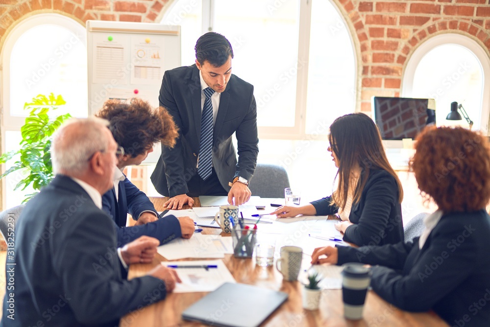 Group of business workers working together in a meeting. Listening one of them speaking at the office. Group of business workers working together in a meeting. Listening one of them speaking at the office.