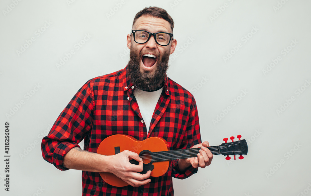 Handsome hipster guy plays ukulele guitar isolate over white background  Stock Photo | Adobe Stock